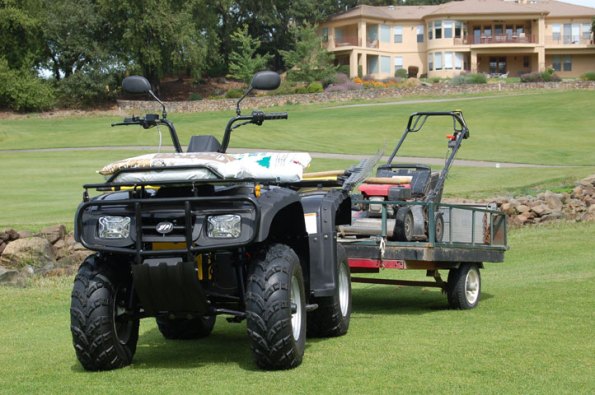 ZAP DUDE electric ATV used for golf course maintenance towing a lawnmower.